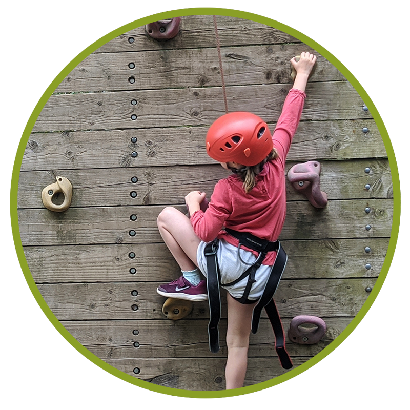 young girl climbing rock wall