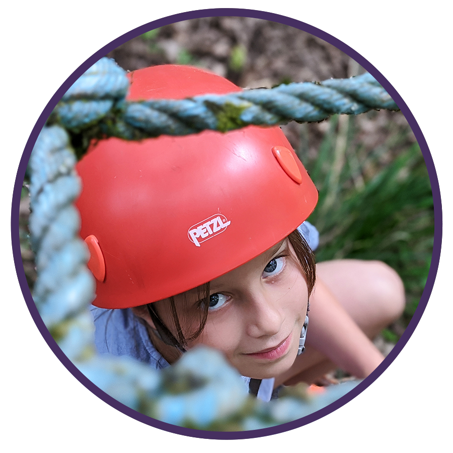 girl wearing red helmet on rope climb