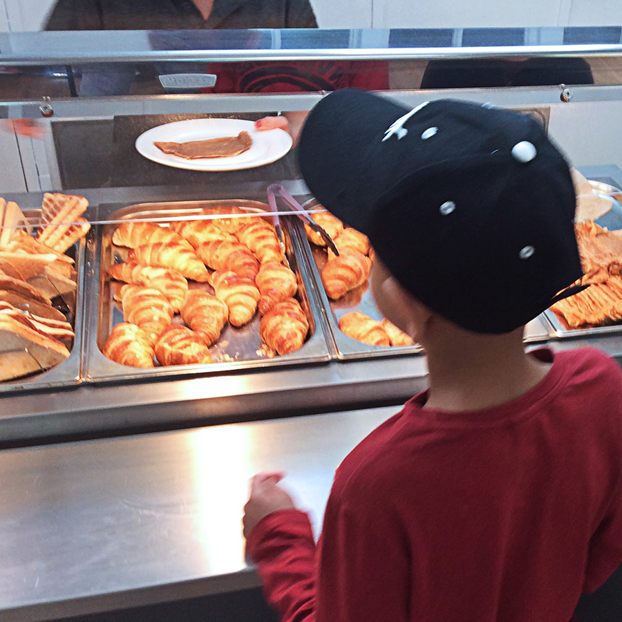 image of a child in a baseball cap getting some food