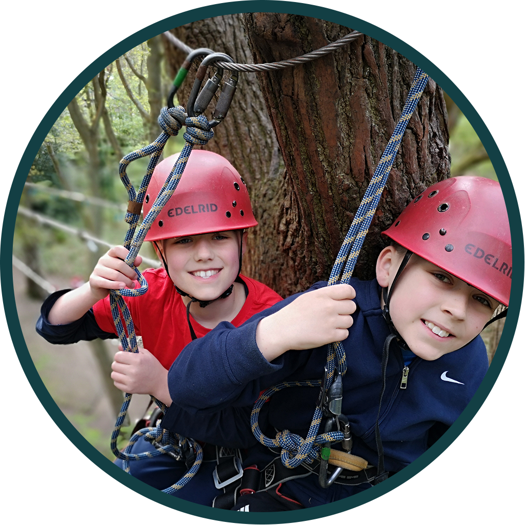circle cropped image of two children on high ropes