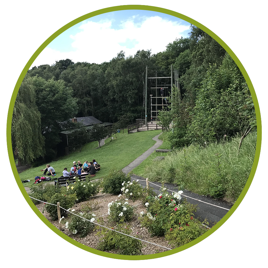 circle cropped image of group sitting nearby high ropes course