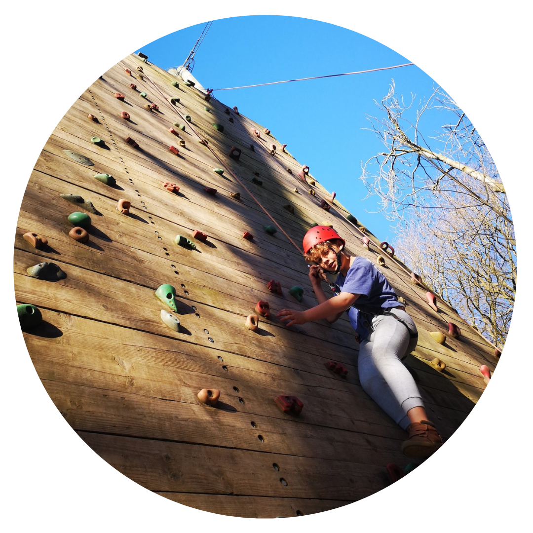 Boy tackling wooden climbing wall