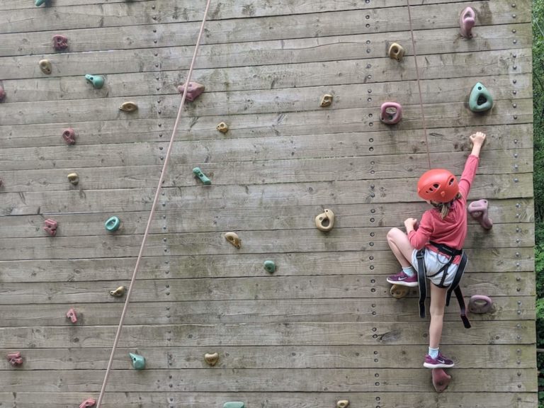 Girl on wooden climbing wall
