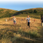 Children running across Malvern Hills on summers day
