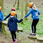Children helping each other on obstacle course