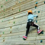 Girl climbing wooden climbing wall