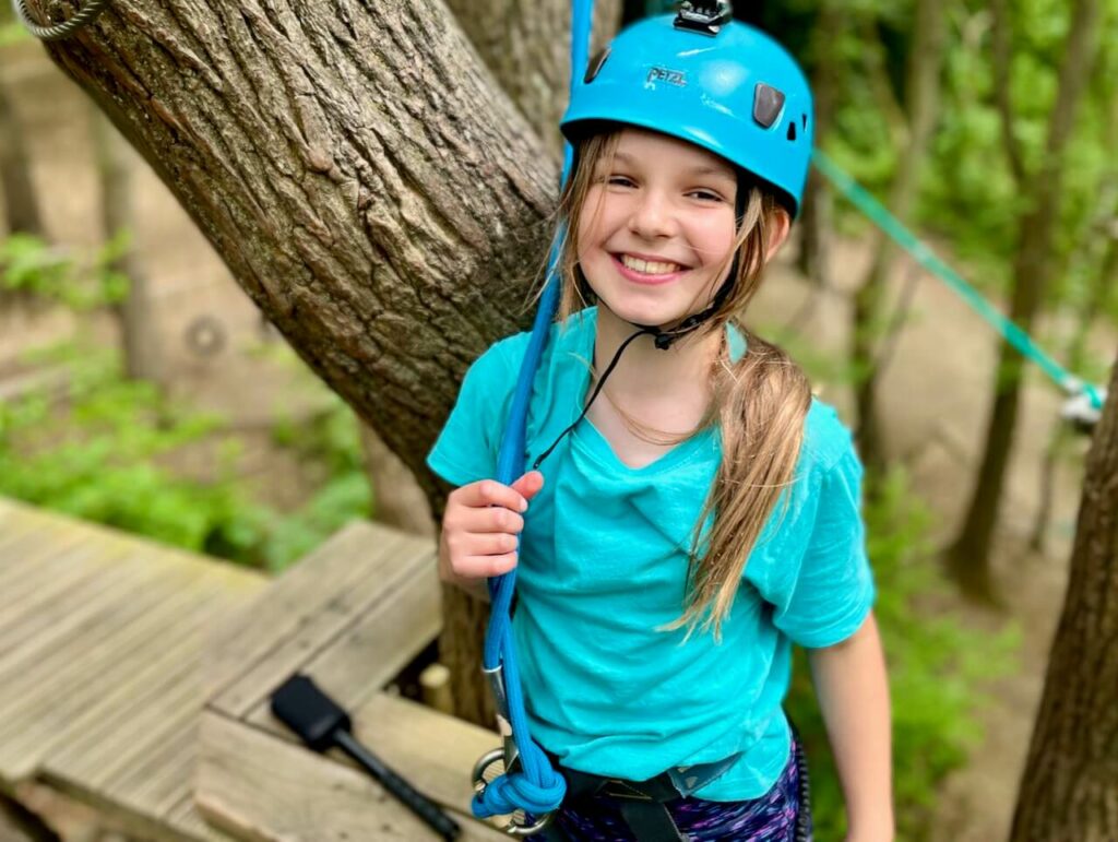 A girl wearing a safety helmet smiling at the camera