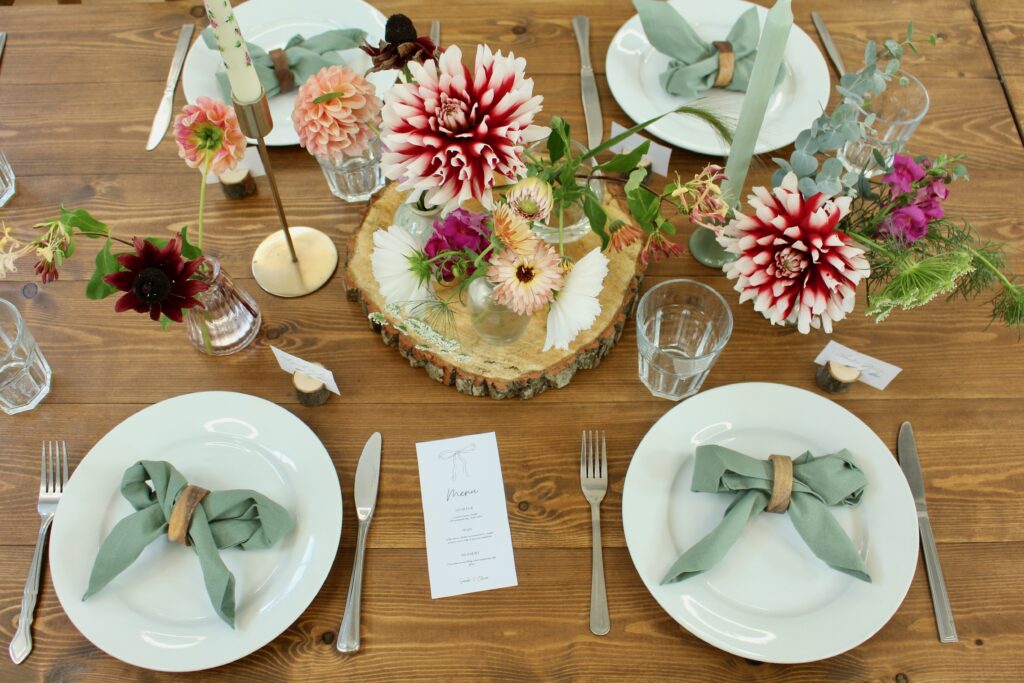 A table setting at a wedding with plates, folded napkins, and flowers